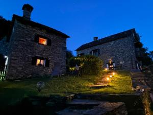 an old stone house at night with lights in the windows at Helle Sonne in Agarone