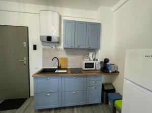 a kitchen with blue cabinets and a sink at Casa Mihuț in Cordău