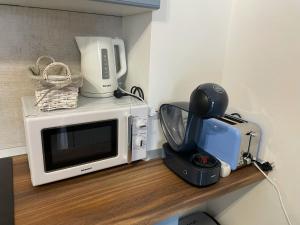a microwave sitting on top of a wooden shelf at Casa Mihuț in Cordău