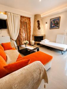 a living room with an orange couch and a fireplace at Villa Christine - Maisonettes with fireplace in Aliveri