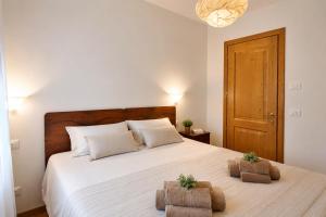a bedroom with a large white bed with two baskets on it at Lhousing - Ideale per Famiglie e Gruppi in Asiago