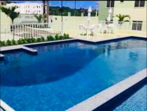 a large blue swimming pool in a building at Day aconchego in Aracaju +10 photos