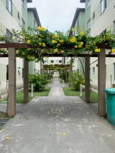 an archway with yellow flowers on it in a courtyard at Day aconchego in Aracaju