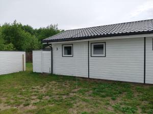 a house with two garages in a yard at Radosna Zatoka - DOMKI Z OGRODZENIEM in Międzywodzie