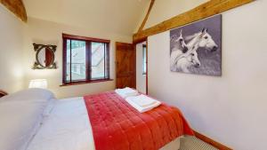 a bedroom with a bed with a picture of a horse on the wall at The Byre in Banbury