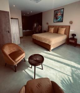 a bedroom with a bed and a chair and a table at La Maison Coloniale Suites privatives de prestige in Torreilles +49 photos