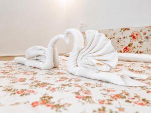 two towel swans sitting on top of a bed at Oldtown Patio in Antalya
