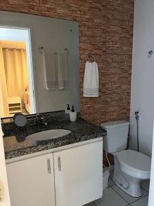 a bathroom with a sink and a toilet and a mirror at Residencial Neo 1 in Maceió +15 photos