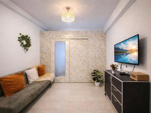 a living room with a couch and a tv at Shore 1 tower D Pasay City in Manila