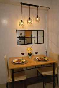 two plates of food on a wooden table with glasses of wine at Shore 1 tower D Pasay City in Manila