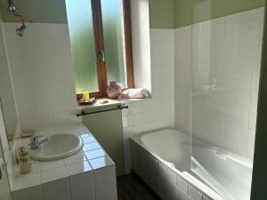 a bathroom with a sink and a bath tub and a sink at Au fil de Lods in Lods +18 photos