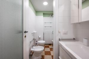 a white bathroom with a toilet and a sink at Casa Camilla - Arty Suite nel centro storico in Parma