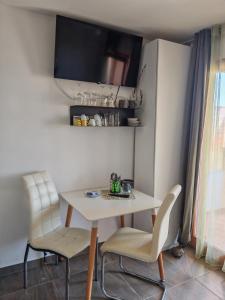 a dining room with a white table and two chairs at Apartment with parking in Dajla