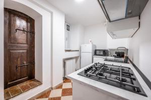 a kitchen with a stove and a refrigerator at Casa Camilla - Arty Suite nel centro storico in Parma