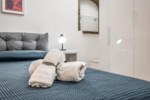 a towel animal is laying on a bed at Casa Camilla - Arty Suite nel centro storico in Parma +11 photos