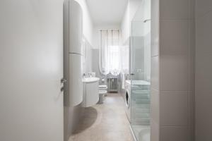 a white bathroom with a toilet and a sink at Casa Amelia - Elegant Suite [parcheggio gratuito] in Parma +28 photos