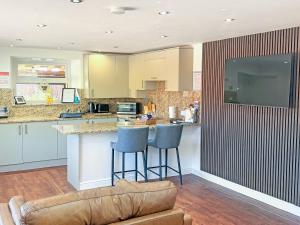 a kitchen with a couch and a bar with stools at Roslyn Cottage in Hamsterley
