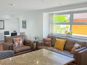 a living room with two couches and a table at Roslyn Cottage in Hamsterley