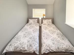 two beds in a small room with at Roslyn Cottage in Hamsterley