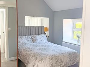 a bedroom with a bed and a window at Roslyn Cottage in Hamsterley