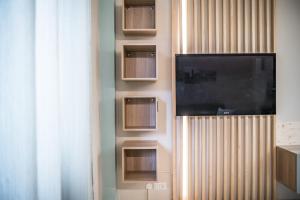 a flat screen tv on a wall with shelves at Casa Amelia - Elegant Suite [parcheggio gratuito] in Parma