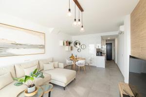 a living room with a couch and a table at NerjaPlus Terraza de Ladera Apartamento V11 in Nerja