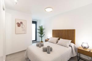 a bedroom with a bed with two pillows on it at NerjaPlus Terraza de Ladera Apartamento V11 in Nerja +22 photos