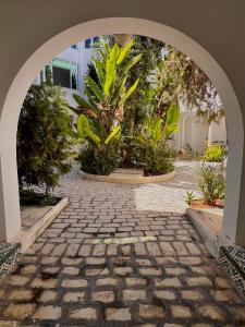an archway leading to a courtyard with plants at la Soukra in Sukrah
