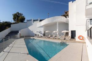 a swimming pool on the side of a building at NerjaPlus Terraza de Ladera Apartamento V11 in Nerja