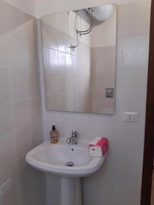 a bathroom with a white sink and a mirror at Tenuta Mazzotti in Lago +24 photos