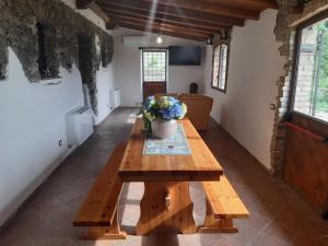 a wooden table in a room with a vase of flowers at Tenuta Mazzotti in Lago