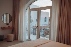 a bedroom with a sliding glass door to a balcony at IONEO Dhermi in Dhërmi