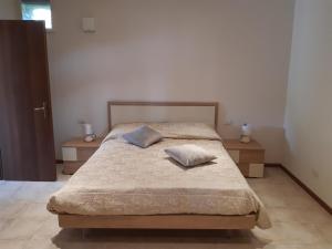 a bedroom with a bed with two pillows on it at Tenuta Mazzotti in Lago