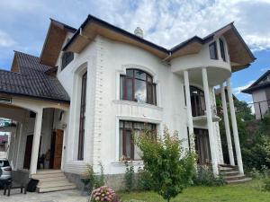 a white house with a black roof at The Landing Nest - Villa in Srinagar