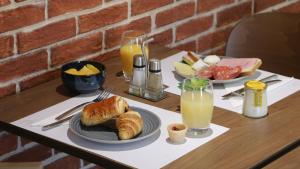 a table with two plates of breakfast food and orange juice at Campanile NATURE - Metz Technopôle in Metz