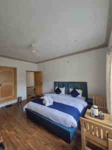a bedroom with a large bed and a wooden floor at Hunder Nature Retreat in Hundar