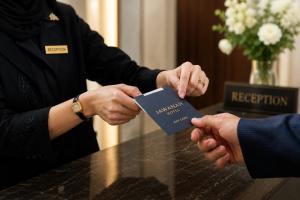 a person handing a card to another person at a table at Jwana in Riyadh