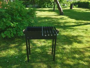 a black grill sitting in the grass in a park at Lerihouse in Saulkrasti