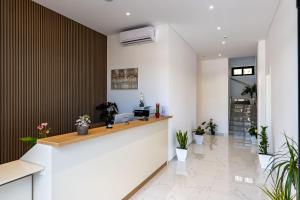 an office lobby with a reception counter and plants at Vila 2M in Sarandë