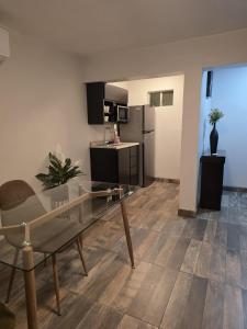 a living room with a glass table and a kitchen at Hotel y Suites Panda in San Luis Río Colorado +10 photos