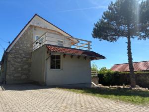 a small white building with a tree in front of it at Csendes Panoráma Apartman in Balatonalmádi