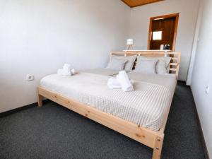 a bedroom with a wooden bed with towels on it at Csendes Panoráma Apartman in Balatonalmádi