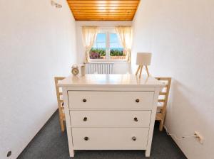 a dresser in a room with a window at Csendes Panoráma Apartman in Balatonalmádi +1 photo