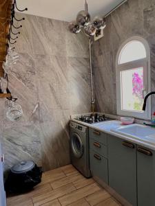a kitchen with a sink and a washing machine at la Soukra in Sukrah +5 photos
