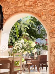 an archway with chairs and tables and flowers at Rida Village Hotel Ksamil Island in Ksamil