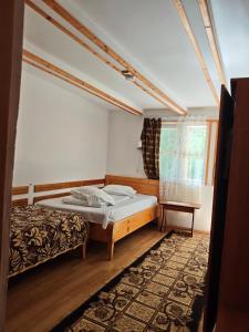 a bedroom with a bed and a window and a rug at 14 Scaune Casoca Tudose in Caşoca