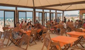 a group of people sitting at tables in a restaurant at Hotel Vela Velo Club Vieste in Vieste