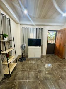 a living room with a fan and a television at The Uptown deluXE Studio #5 in Balulang