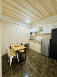 a kitchen with a table and chairs and a refrigerator at The Uptown deluXE Studio #5 in Balulang