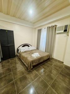 a bedroom with a bed and a tiled floor at The Uptown deluXE Studio #5 in Balulang